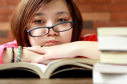 Student resting chin on book